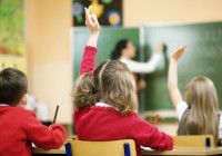 Children Raising Hands In Class, Rear View